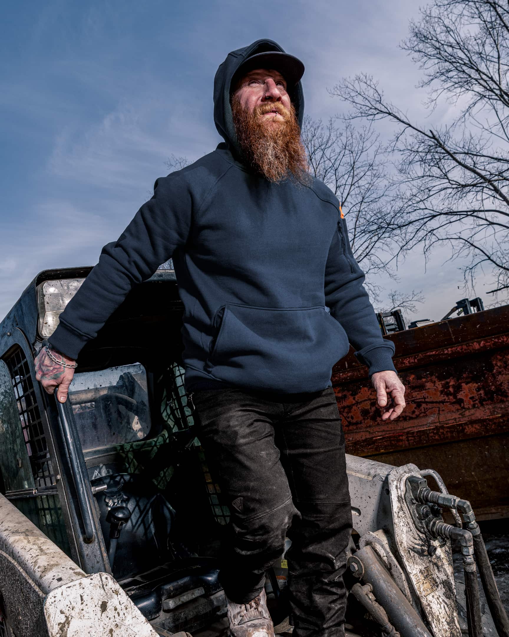 Men’s heavyweight fleece hoody in blue worn on construction site, stepping out of machinery – SKU WW-PO-600 | color:Detroit Blue