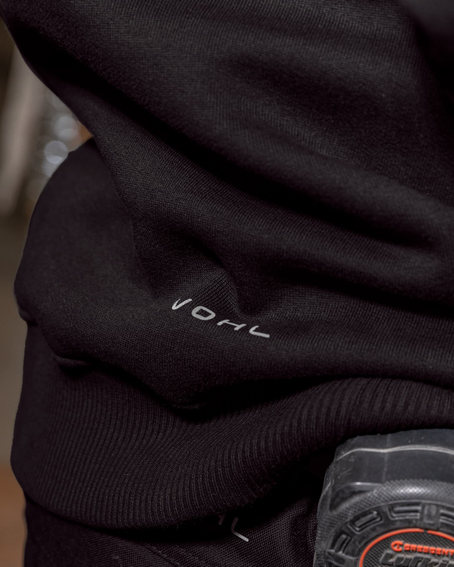 Close-up of Black heavyweight fleece hoody hem with Vohl logo detail – SKU WW-PO-900 | color:Black